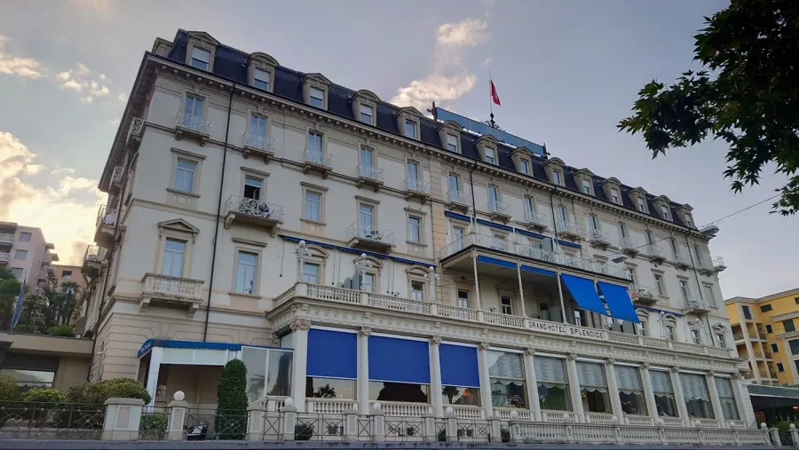 Façade élégante d'un grand hôtel européen avec volets bleus et architecture baroque, Lugano