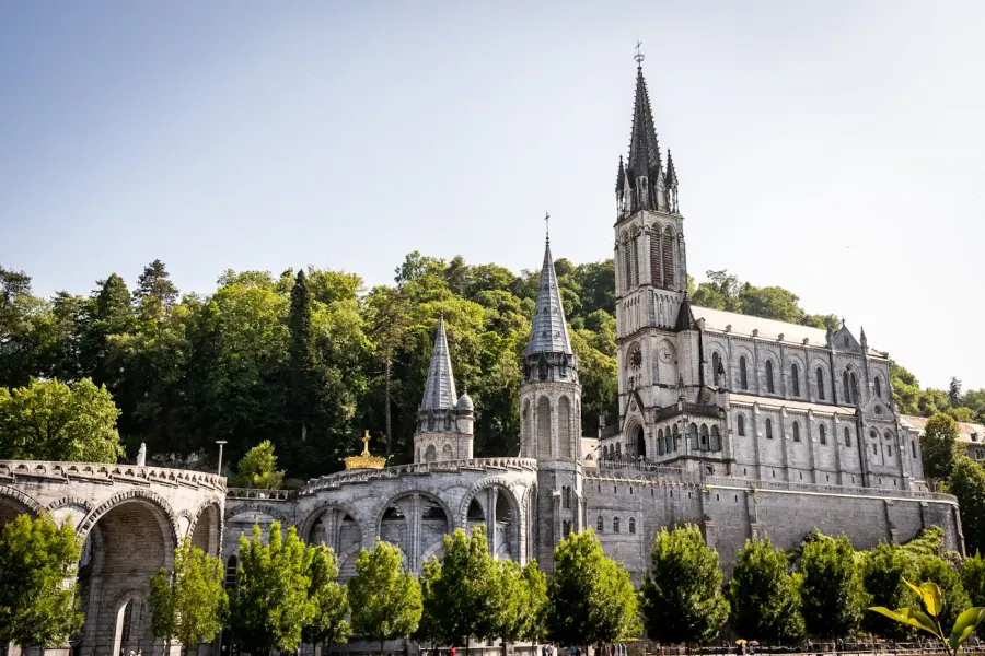 Basilique de l'Immaculée Conception à Lourdes, France — clocher majestueux sous un ciel clair