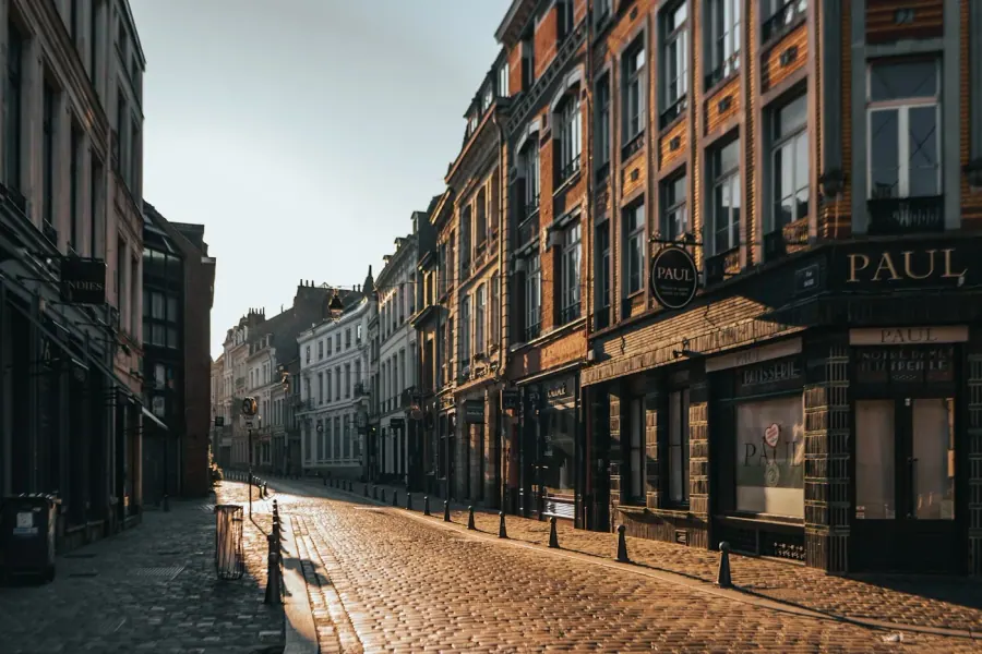 Rue pavée d'une ville européenne au lever du soleil, architecture historique et façades colorées